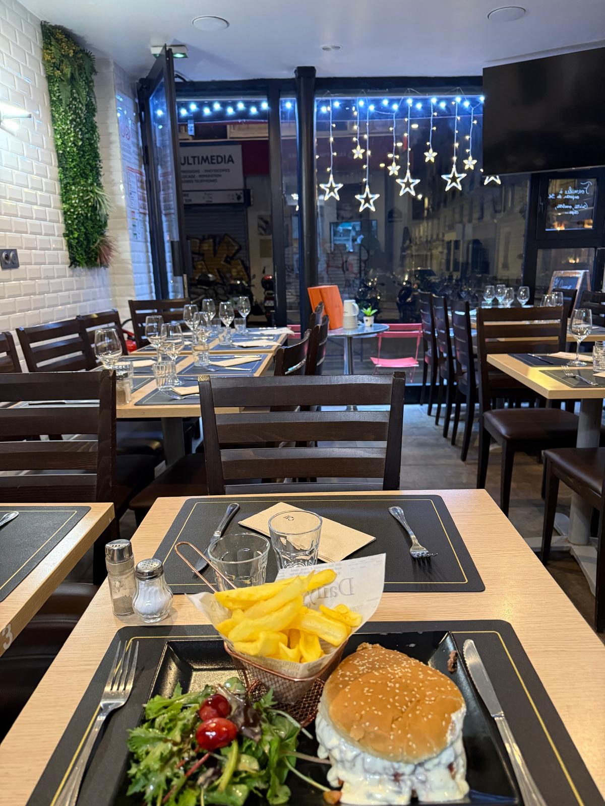Salle du restaurant dressée en soirée